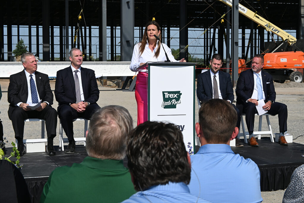 Governor Sarah Huckabee Sanders standing at a podium speaking to a crowd of people.